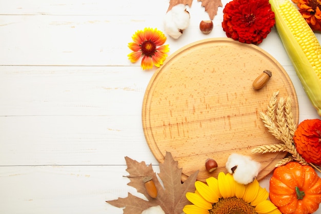 Autumn composition. Frame made of fresh flowers on white wooden background. Flat lay, top view, copy space. Thanksgiving day with copy space.