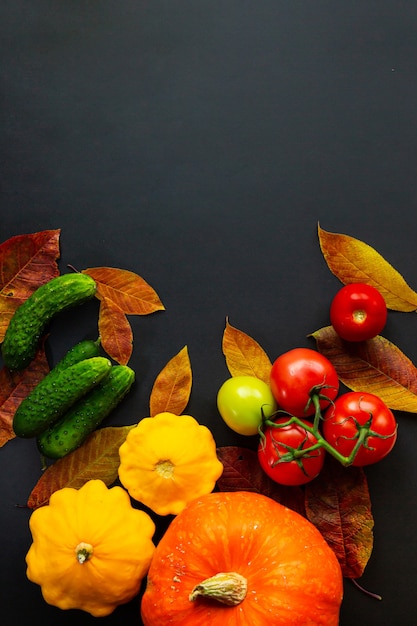 Осенняя композиция из овощей и листьев на черном столе