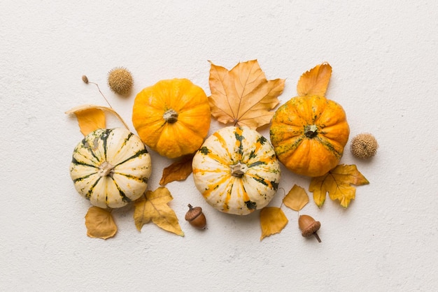 Composizione autunnale motivo fatto di foglie essiccate e altri accessori di design sul tavolo vista dall'alto piatto