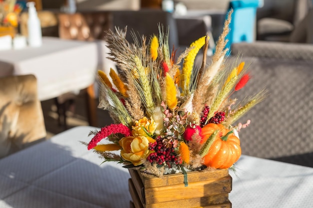 Autumn composition Pumpkins candles and dried flowers Autumn holidays fall thanksgivinghalloween concept cozy home still life Dry flowers in a vaseConcept of rich harvest and festive mood