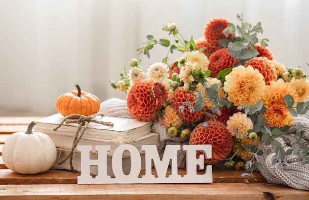 Foto composizione autunnale con un mazzo di crisantemi e casa di parole decorative