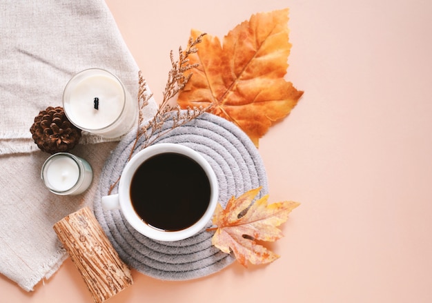 Autumn composition with candles, coffee cup and leaves