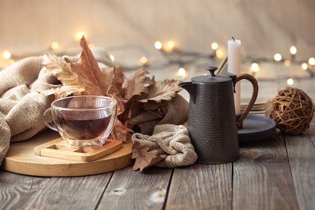 Autumn composition with a cup of tea and decorative items. Cold season home comfort concept.