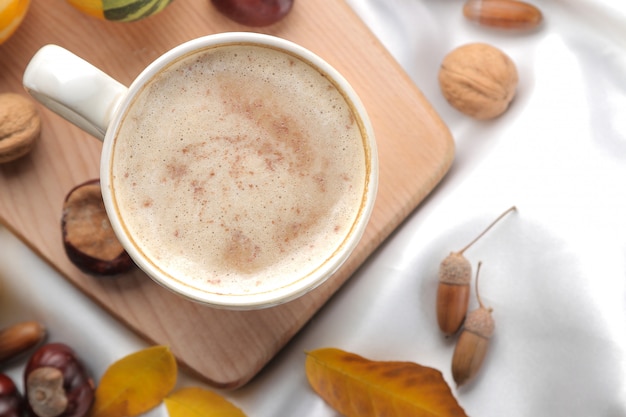 ベッドの上のトレイにホットコーヒーと黄色の葉の秋の組成物。上からの眺め