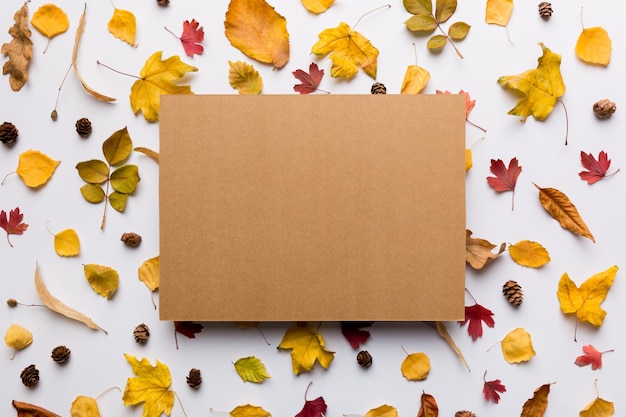 Autumn composition with paper blank and dried leaves on table Flat lay top view copy space