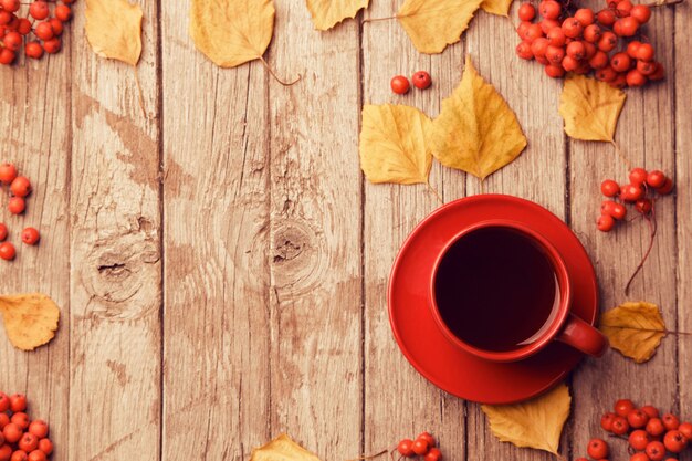 Foto composizione autunnale con area di lavoro con taccuino in bianco, matita, tazza di caffè rossa e belle foglie di acero rosse. vista dall'alto, disteso, tonalità vintage. l'autunno si rilassa il concetto