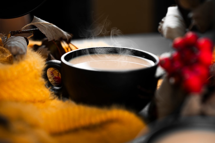 Photo autumn composition. yellow sweater, coffee, rowanberry on a dark background. high quality photo