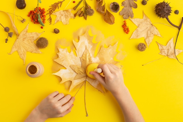 Autumn concept flatlay collection of maple leaves painted in gold on yellow diy high quality photo