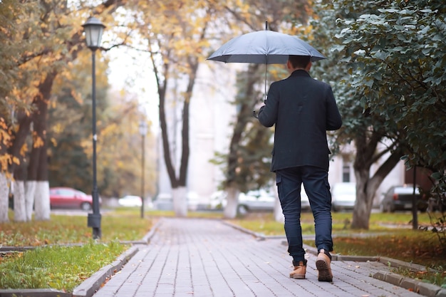 Concetto di autunno. piedi dei pedoni sulla strada. foglie d'autunno sul sentiero.