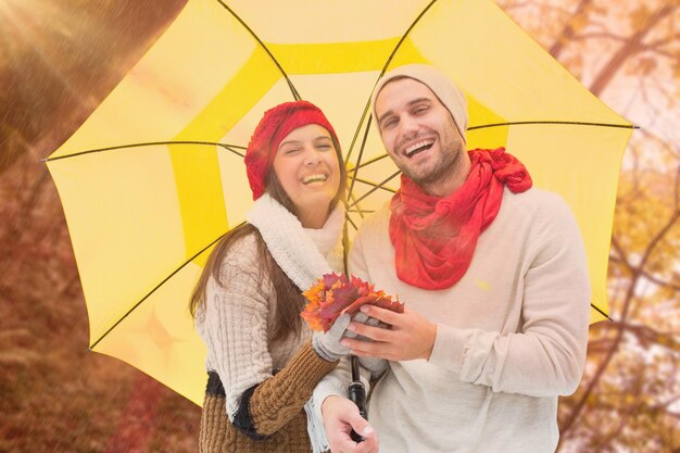 Autumn couple holding umbrella against tranquil autumn scene in forest