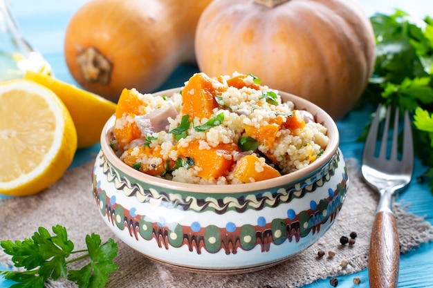 Autumn Couscous with pumpkin and vegetables on wooden table