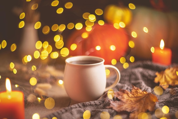 Autumn cozy composition Tea in a mug pumpkins and candles