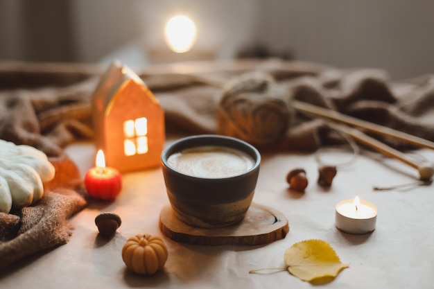 Autumn cozy home interior with a cup candles plaid Hygge home decor Halloween and Thanksgiving concept