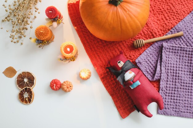 Autumn cozy still life with toy candles pumpkin and leaves