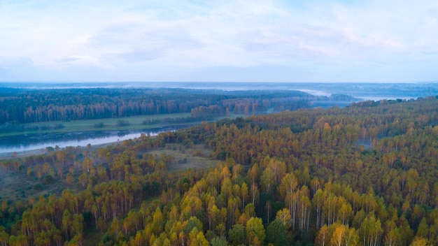 Autumn dawn over foggy forest and river aerial drone view