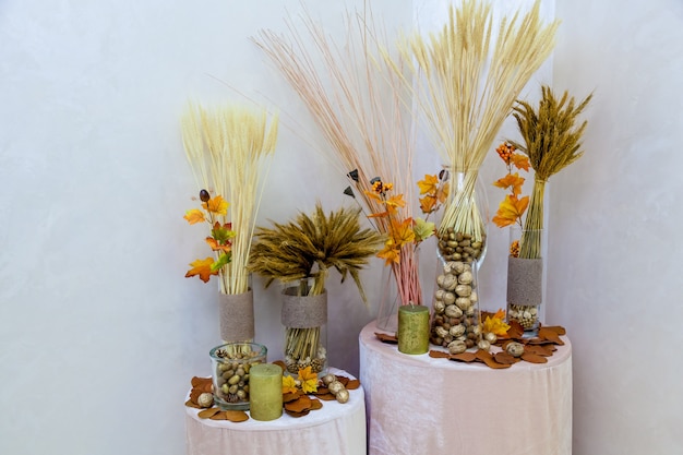 Photo autumn decoration of nuts from yellow leaves and candles. autumn decoration for interior handmade