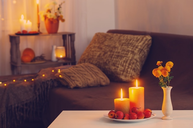 Autumn decorations with burning candles at home