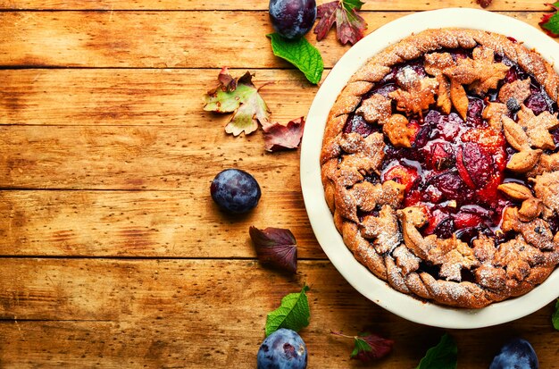 Autumn delicious pie with plum.Tart with fresh plums.Fruit appetizing summer cake.Space for text