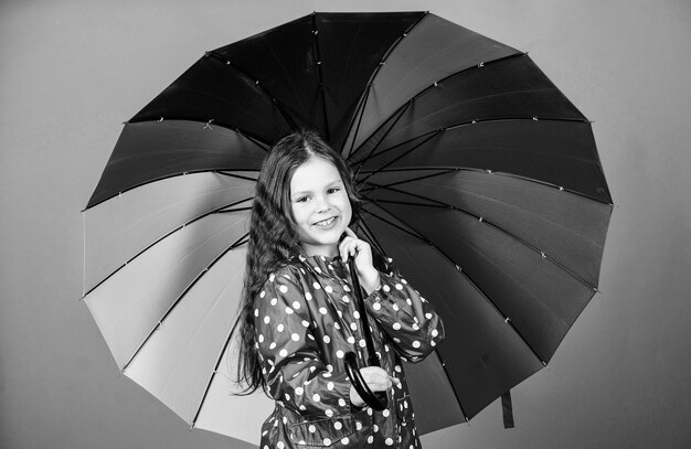 Autumn fashion little girl in raincoat rain protection Rainbow cheerful hipster child in positive mood happy little girl with colorful umbrella In her own style Life is awesome