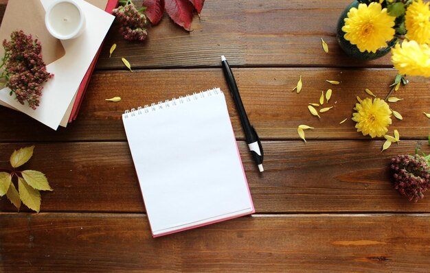 Photo autumn flat lay composition with blank paper card letter envelope coffee cup scarf fallen leaves on beige background autumn hygge style desk table top view