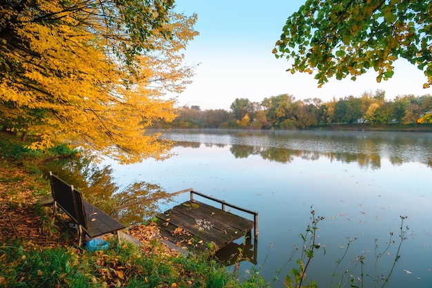 Autumn foliage lake in morning with pier