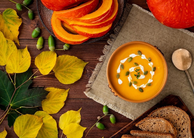 Photo autumn food pumpkin puree soup leaves dark brown old wooden table top view