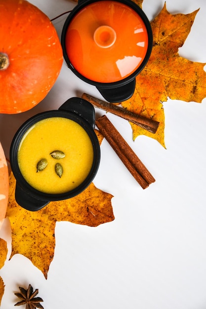 Photo autumn food pumpkin puree soup leaves top view autumn harvest pumpkins leaves on grey