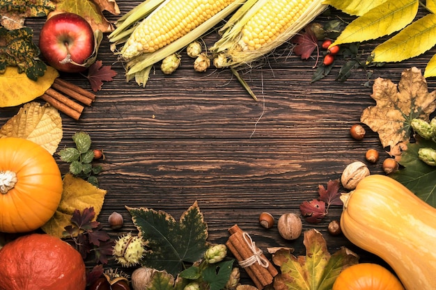 Vista dall'alto del cibo autunnale sfondo del ringraziamento o di halloween zucche noci foglie cadute e spezie