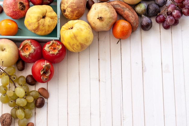 Autumn fruits on white wooden table