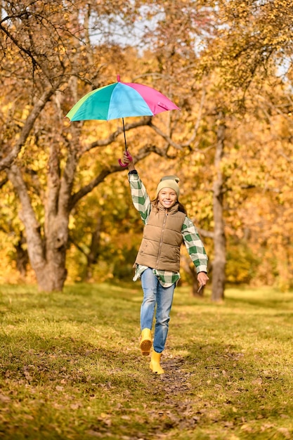 Autumn. A girl with a bright umbrella in an autumn park