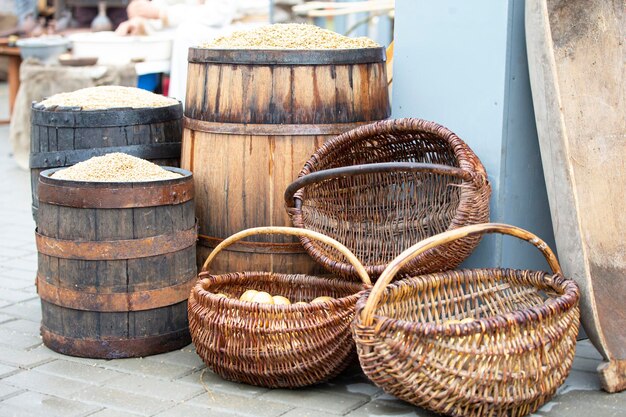 Autumn harvest at the fair Wooden barrels with grain and wicker baskets with potatoes