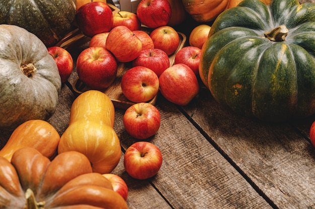 Autumn harvest of pumpkins and apples on old wooden board