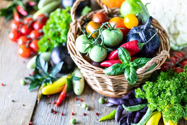 Autumn harvest of vegetables in a wicker basket: tomatoes, beans, squash, pumpkin, cabbage, greens, parsley.