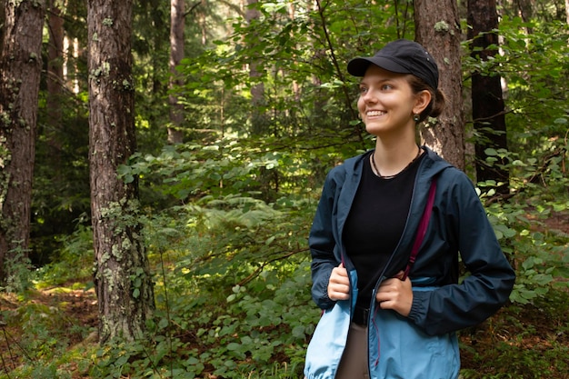 Autumn hike tourist lifestyle woman walking on trek trail in forest outdoors Summer autumn active girl with a backpack hiking outdoors