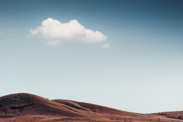 Photo autumn hills and the blue sky with white cloud