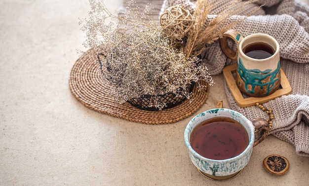 Composizione domestica autunnale con una bella tazza di tè in ceramica sul tavolo.