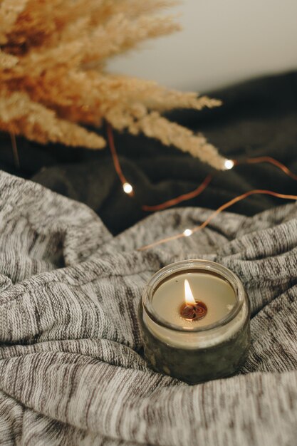 Autumn home decor with a candle and dry plant