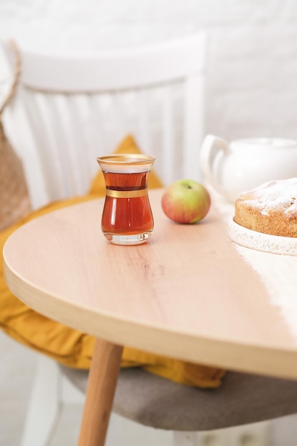 Autumn home decoration a cup of tea apple pie white teapot on round wooden table on white background