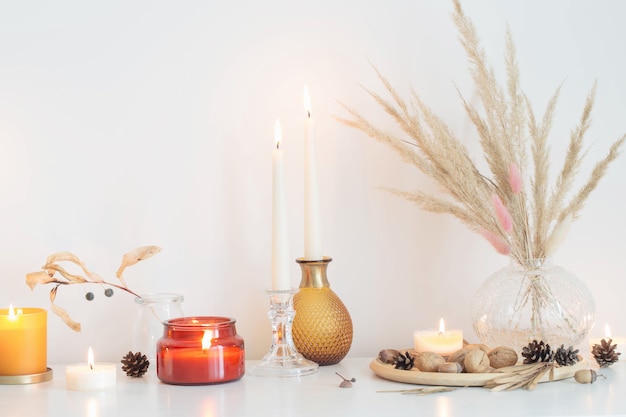 Autumn home decorations with burning candles