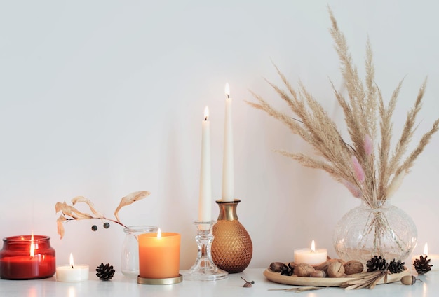 Autumn home decorations with burning candles