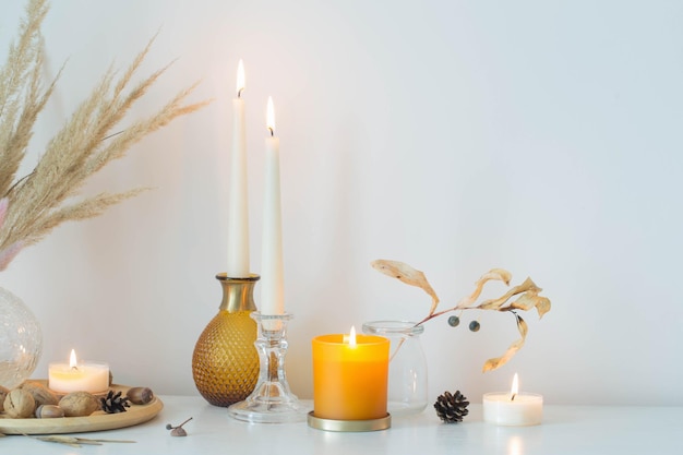 Autumn home decorations with burning candles