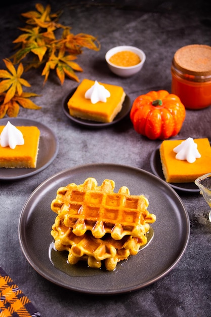 Autumn homemade pumpkin spice waffles with honey topping.