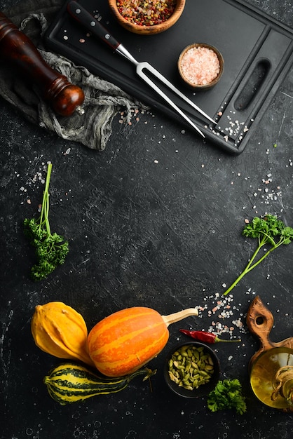 Foto sfondo cucina autunnale zucche sul tavolo con spezie e utensili da cucina spazio libero per il testo vista dall'alto