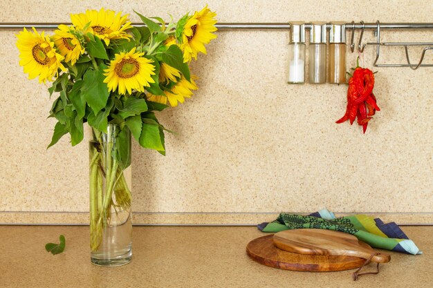 Autumn kitchen interior and bouquet of sunflowers on a stone\
countertop copy space