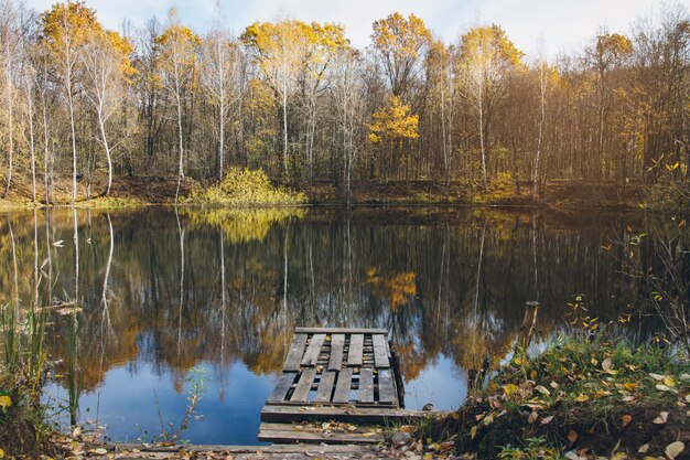 Lago autumn con un vecchio ponte di legno