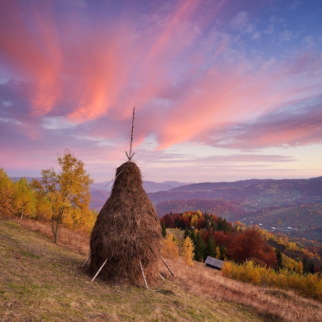 Осенний пейзаж с стопом сена в горах