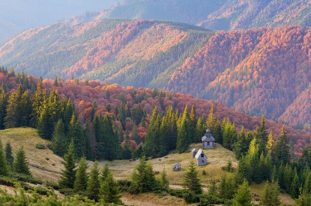 Autumn landscape with old wooden church in the mountains