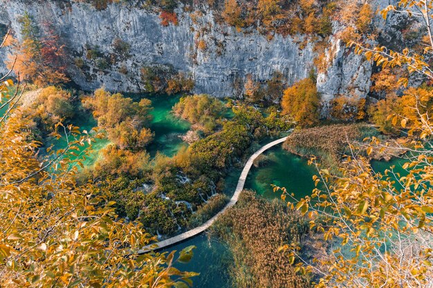 写真 クロアチアのプリットヴィチェ湖国立公園の湖を横断する道と秋の風景