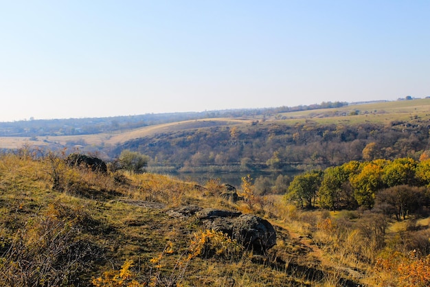 Autumn landscape with trees hills and sky