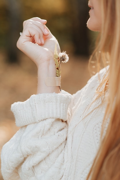 Foto foglia d'autunno incollata con gesso su un ritratto autunnale della mano di una donna